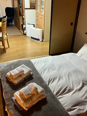 A futon made up on tatami, with towels and yukata folded at the foot